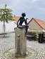Socha sedící ženy s dlouhými prsty
